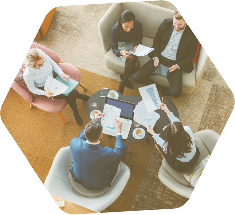 A group of businesspeople, seated around a coffee table, collaborating on a project.